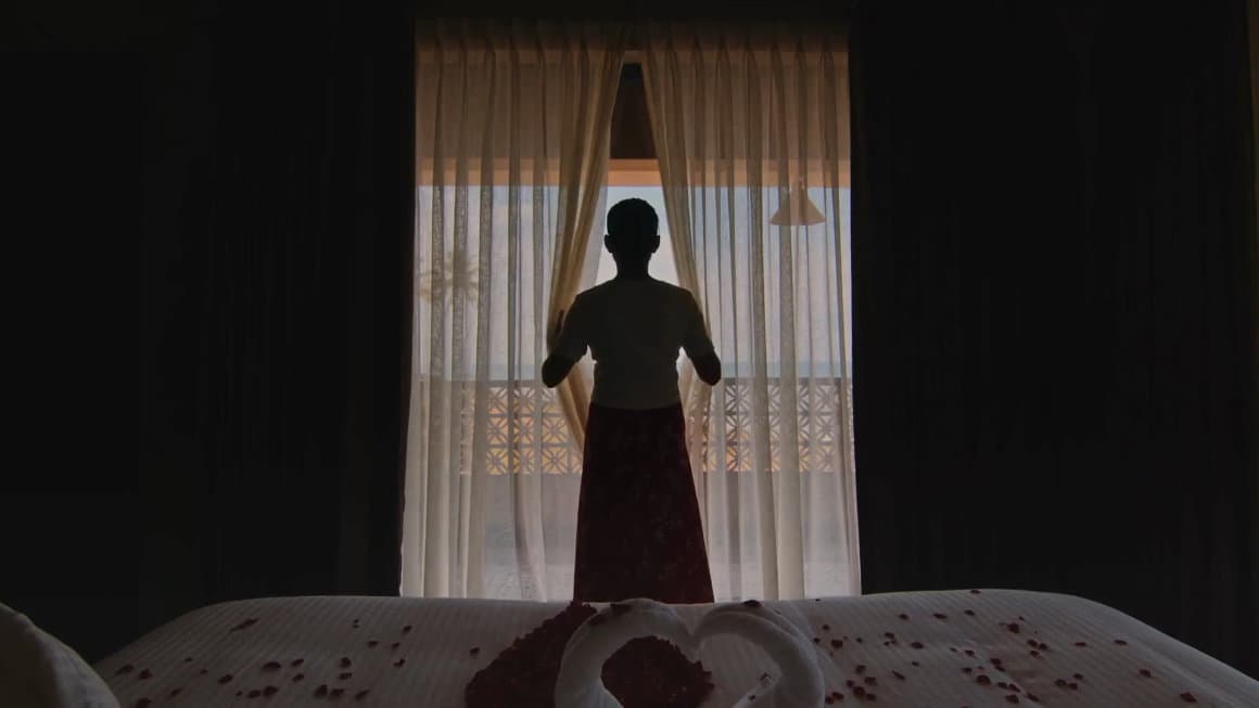 Housekeeper opening the curtains of a five star hotel room