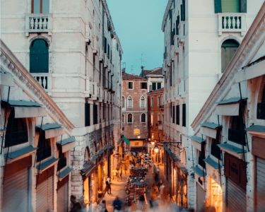 People walking down Rialto bridge in Venice